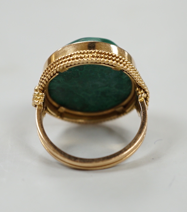 A yellow metal and cabochon malachite set dress ring, size F/G